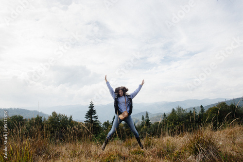 beautiful happy stylish traveling girl  in the mountains on a ba