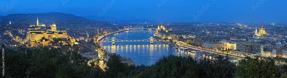 Evening panorama of Budapest, view from Gellert Hill, Hungary. The panorama shows: Buda Castle, Danube river with Szechenyi Chain Bridge, Hungarian Parliament Building and St. Stephen's Basilica.