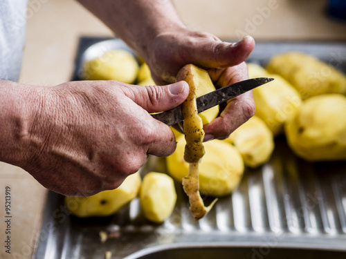 Hands peeling potatoes