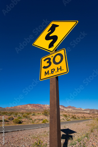 Close-up of yellow road sign in desert, California