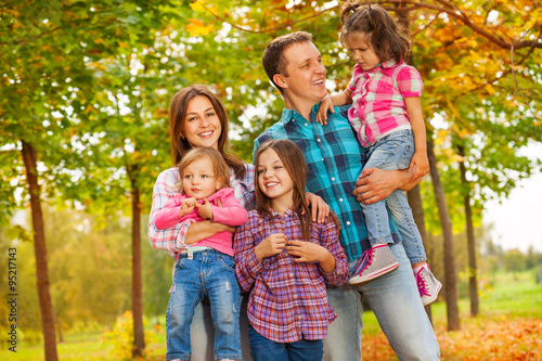 Family portrait in autumn park with little girls