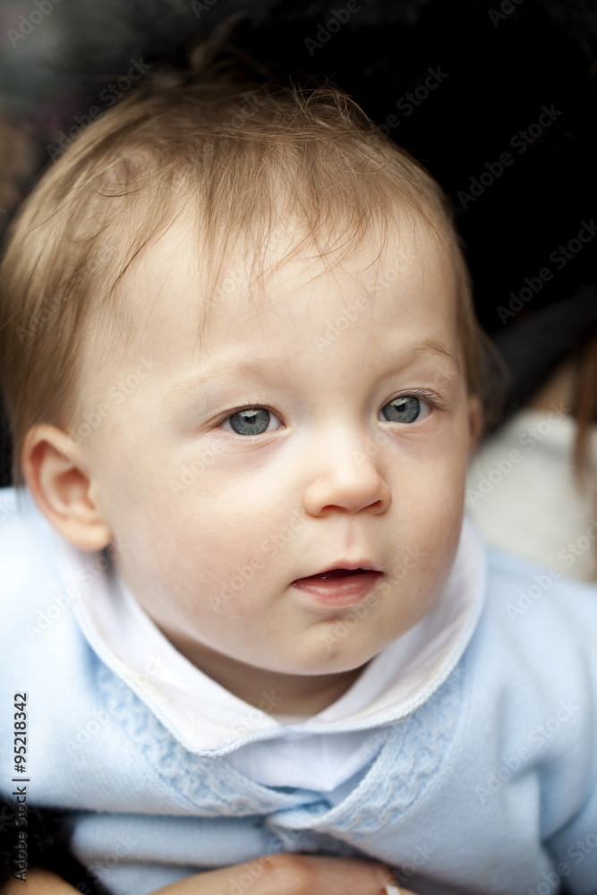 Baby Boy. A head shot of a baby boy who is looking at something out of the image.