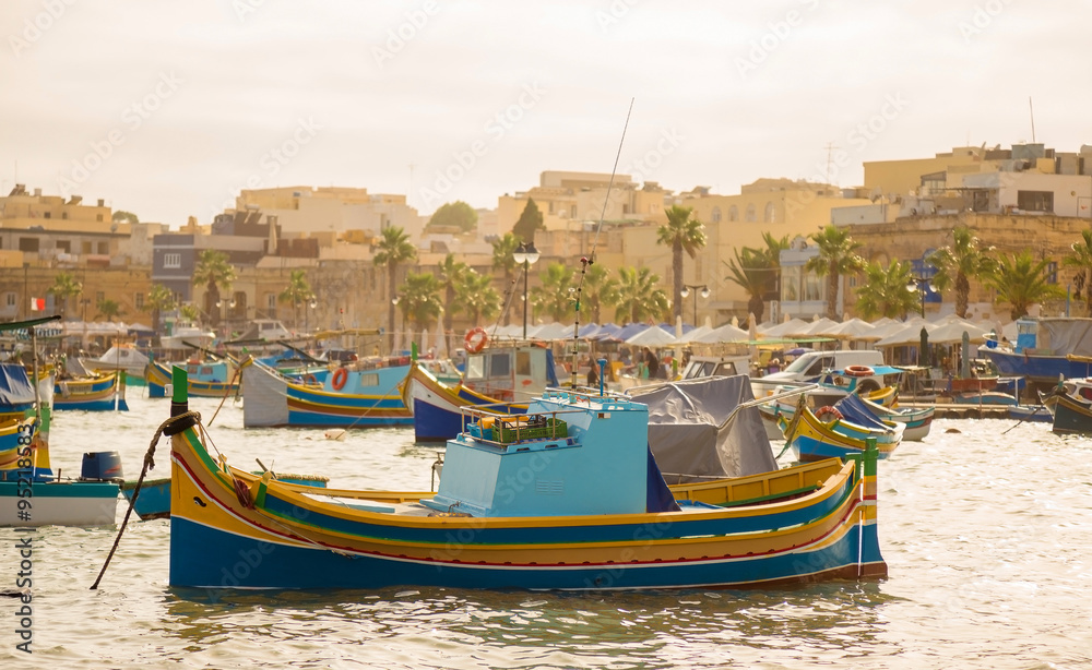 Traditional Luzzu fishing boats at Marsaxlokk Market at morning - Malta