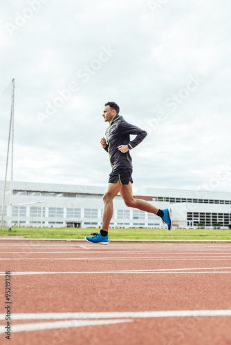 Attractive man Track Athlete Running On Track