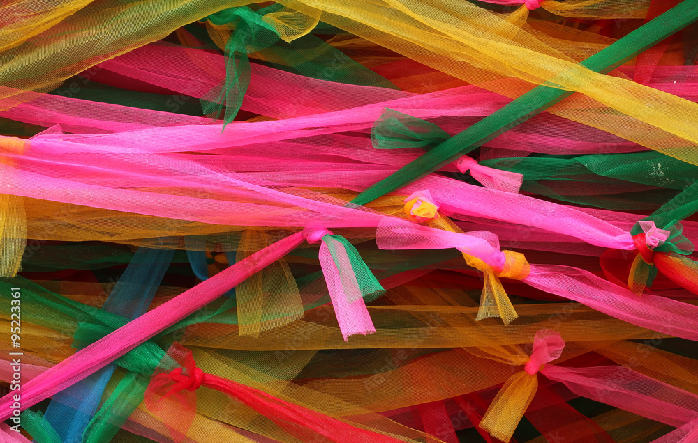 Strips of different colored fabric ribbons decorate a bodhi tree