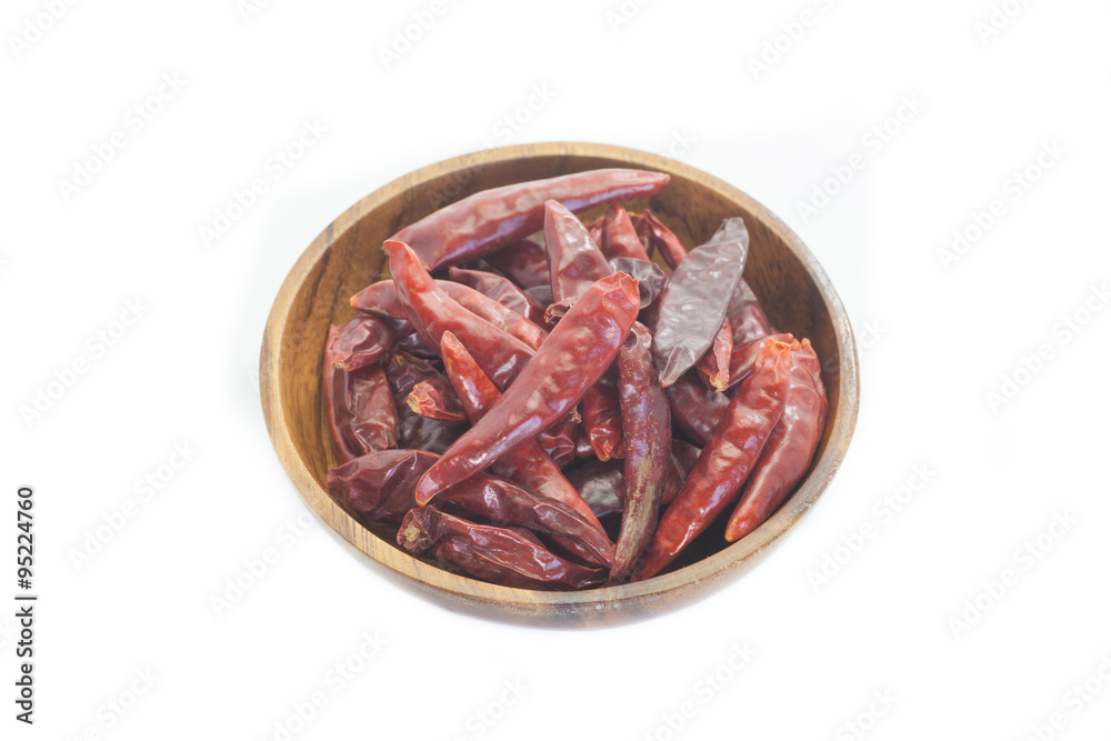 Dried chili pepper in wooden bowl on white background