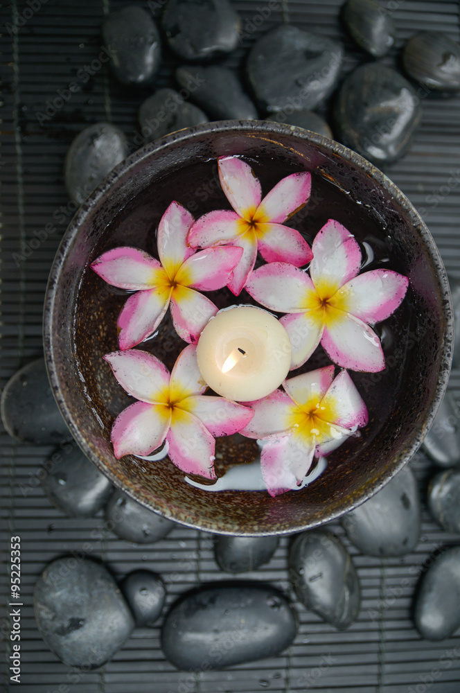 frangipani with candle in bowl and zen stones on bamboo mat
frangipani with candle in bowl and zen stones on bamboo mat