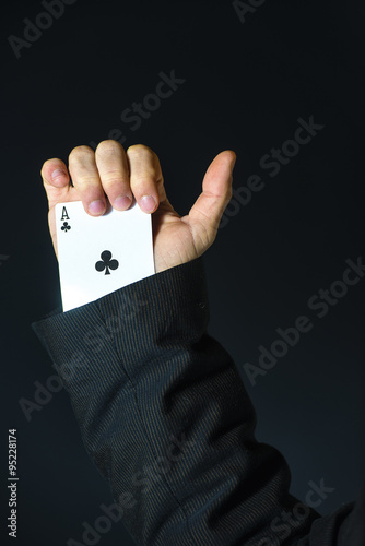 Man with ace up his sleeve on black background