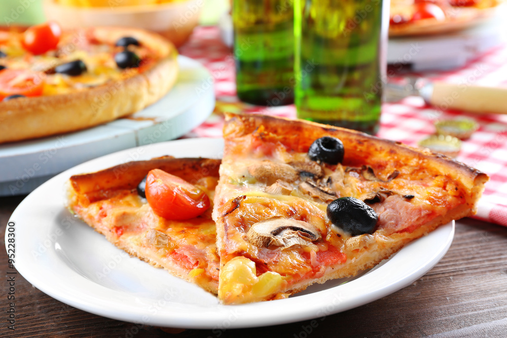 Sliced pizza served with beer on wooden table Sliced pizza served with beer on wooden table