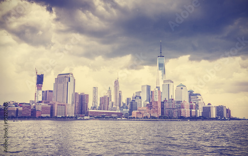 Vintage toned picture of New York waterfront with dramatic sky.