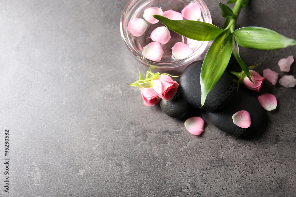 Spa composition of stones, flowers and petals, on grey background Spa composition of stones, flowers and petals, on grey background