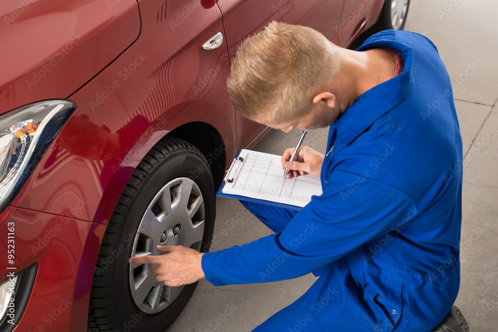 Mechanic Examining Car Wheel Mechanic Examining Car Wheel