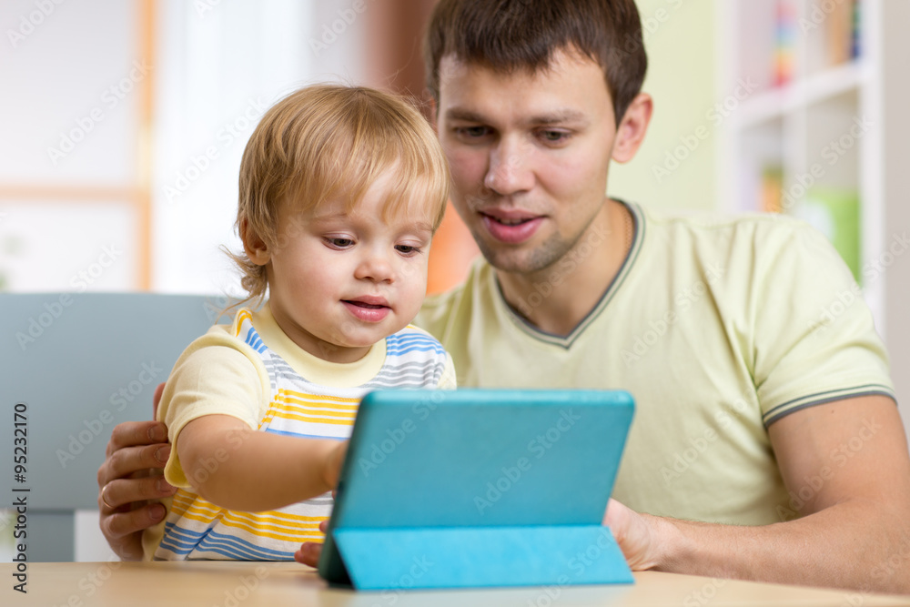 father and son kid playing with tablet computer indoors father and son kid playing with tablet computer indoors