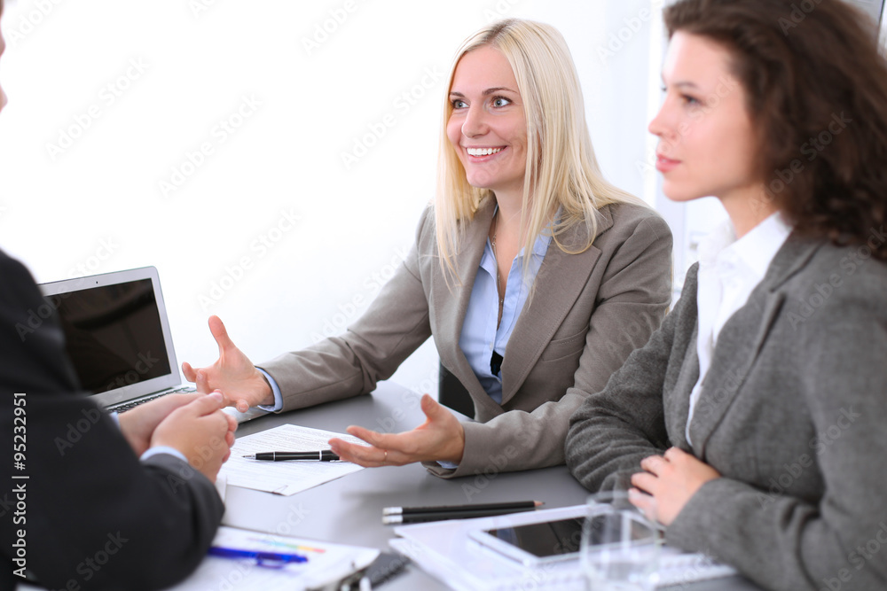 A group of business people at a meeting on the background of office. Focus on a beautiful blonde