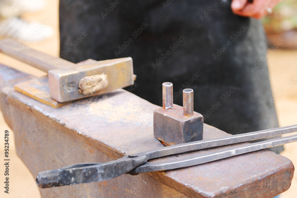 Metal anvil, hammer and tongs for blacksmith working outdoor Metal anvil, hammer and tongs for blacksmith working outdoor