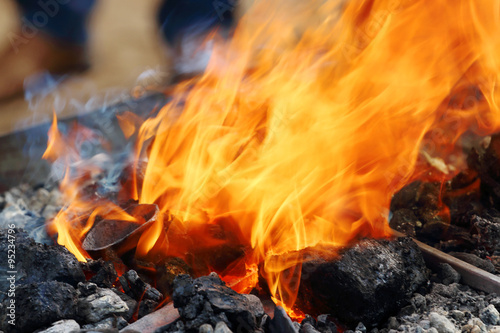 Close up view of burning coals with bright orange flame 