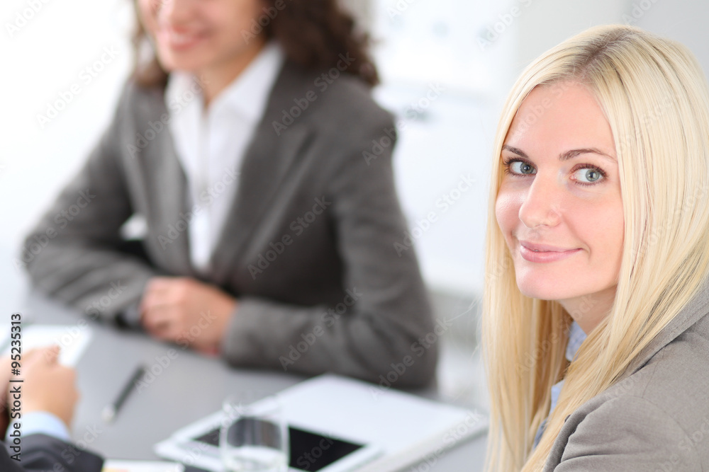 A group of business people at a meeting on the background of office. Focus on a beautiful blonde A group of business people at a meeting on the background of office. Focus on a beautiful blonde