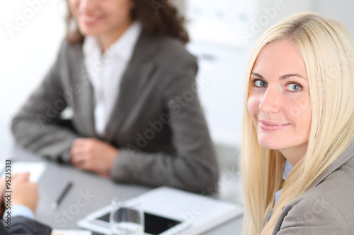 A group of business people at a meeting on the background of office. Focus on a beautiful blonde