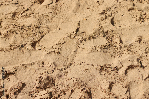 Many different footprints on yellow sand 