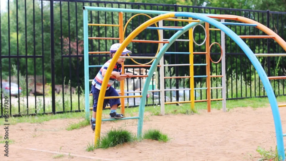 Happy little boy plays on children playground at summer day
Happy little boy plays on children playground at summer day