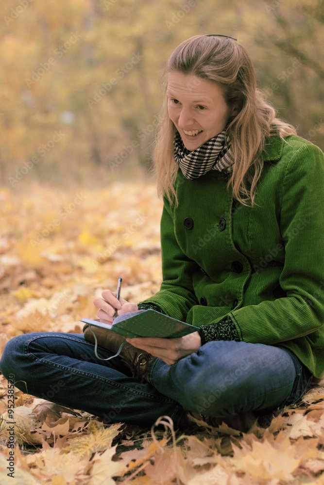 Girl in autumn leaves with a notebook Girl in autumn leaves with a notebook