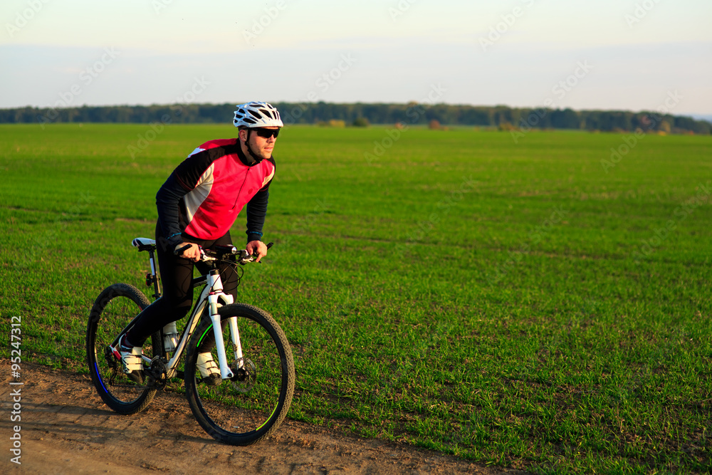 young adult cyclist riding mountain bike in the countryside young adult cyclist riding mountain bike in the countryside
