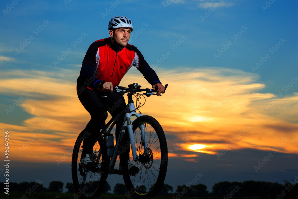 young adult cyclist riding mountain bike in the countryside young adult cyclist riding mountain bike in the countryside