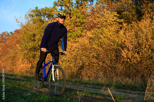 young adult cyclist riding mountain bike in the countryside