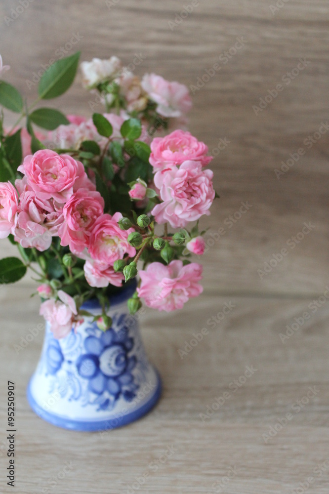 Small pink roses in a vase, texture background