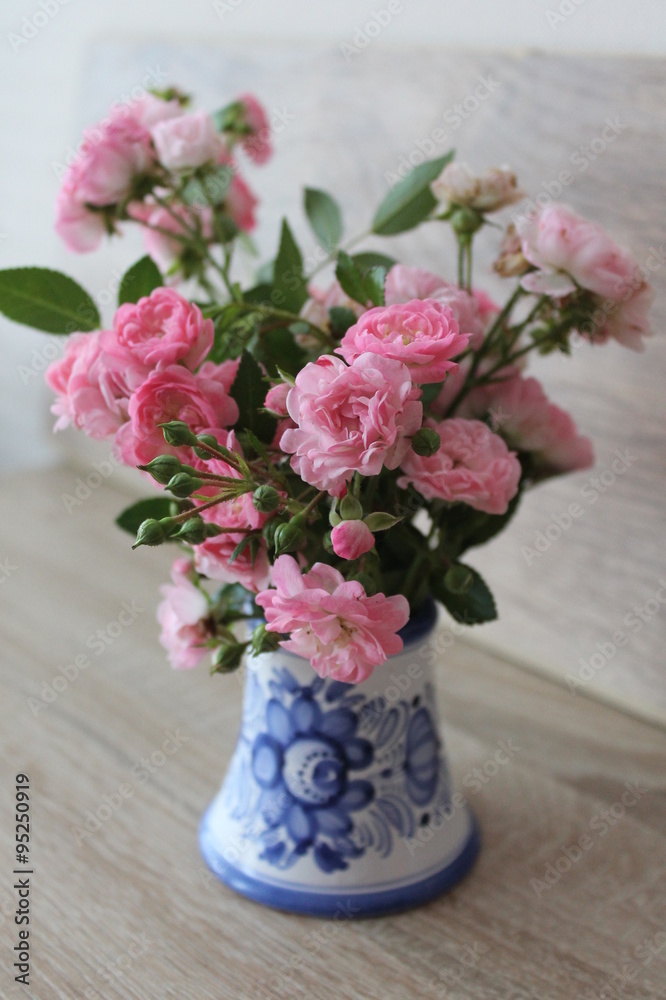 Small pink roses in a vase, texture background
