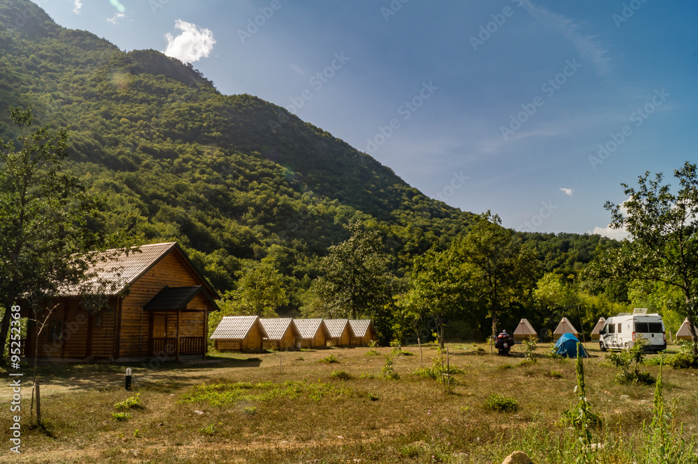 Green tourism in rural mountainous region with camping and little woody lodges.
