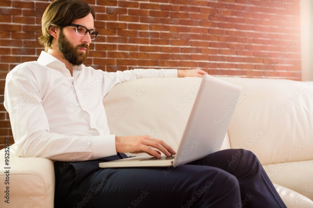 Businessman using laptop on the couch Businessman using laptop on the couch