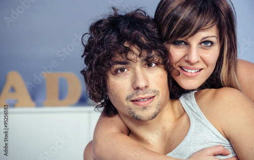 Couple in love embracing and smiling on bedroom