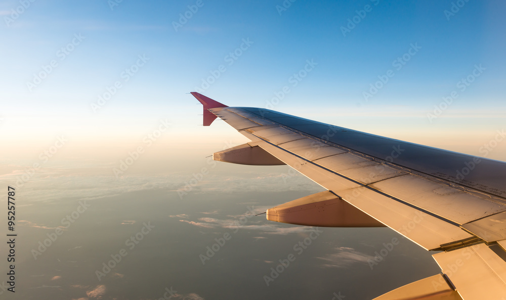 Fototapeta premium Airplane Wing in Flight from window with sunset sky