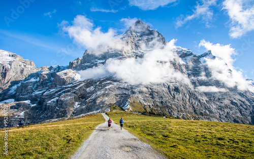 Two runners on the pass way to Grosse Scheidegg above Grindelwald, Switzerland. photo