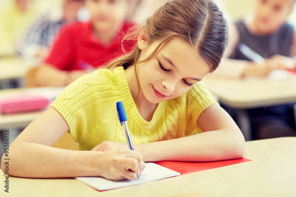 group of school kids writing test in classroom group of school kids writing test in classroom