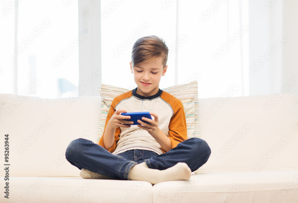 boy with smartphone texting or playing at home boy with smartphone texting or playing at home