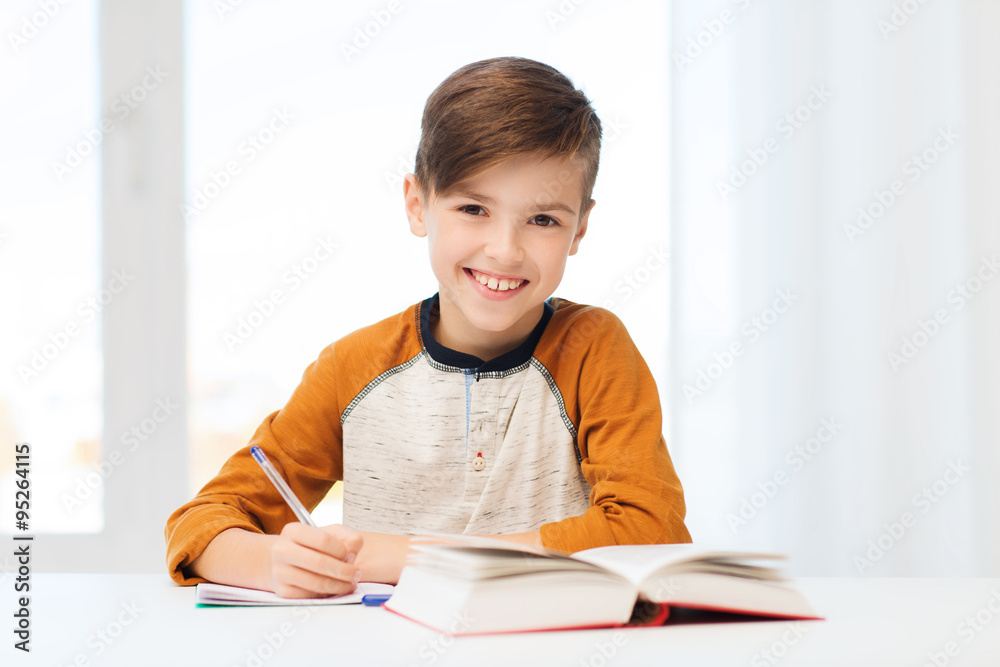 smiling student boy writing to notebook at home smiling student boy writing to notebook at home