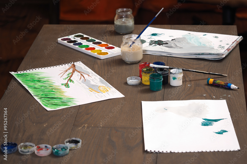 Краски, бумага, детские рисунки на столе. Гуашь. Разноцветные рисунки.  Рисование. Дети учатся рисовать Stock Photo | Adobe Stock