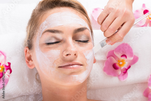 Beautician Applying Mask On Customer's Face At Salon