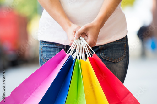 Midsection Of Woman Holding Colorful Shopping Bags