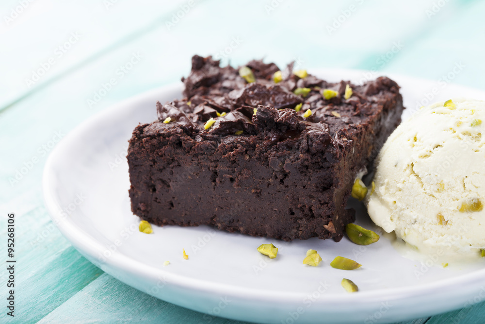 Chocolate brownie, cake, white plate on a turquoise wooden background