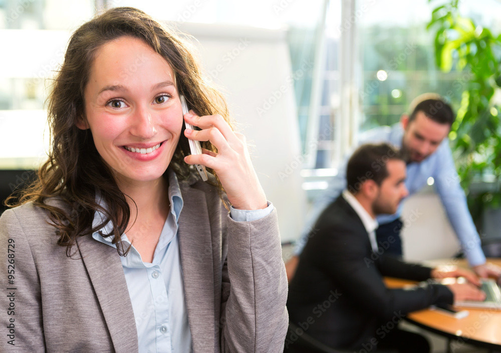 Young attractive businesswoman working at the office with associ Young attractive businesswoman working at the office with associ