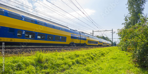 Passenger train driving at high speed in summer