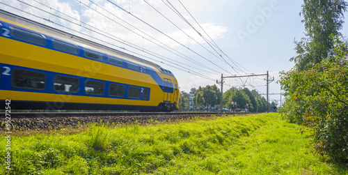 Passenger train driving at high speed in summer