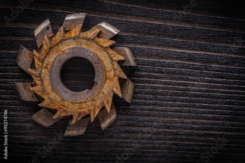 Rusted rotary cutter on vintage wooden board construction concep photo