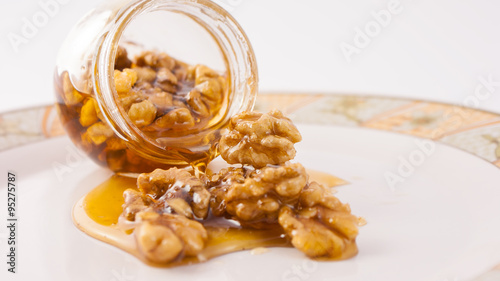 Walnut and honey dripping from jar