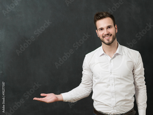 Portrait of a serious young man standing against chalkboard