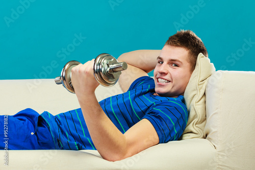 Young man fit body relaxing on couch after training photo