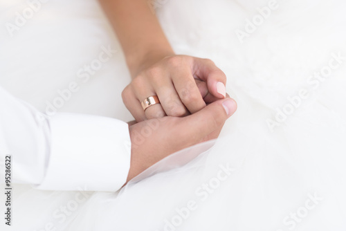 the groom holds the bride's hand